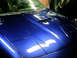 1993 Ford Probe - The hood of a blue 1993 Ford Probe is visible, with a scoop and pop-up headlights.