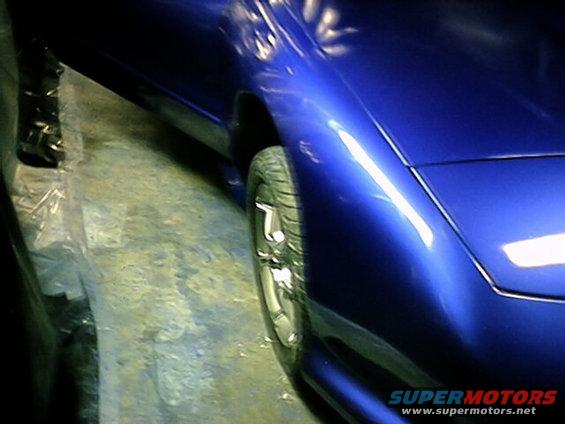 Blue car fender and wheel, side view