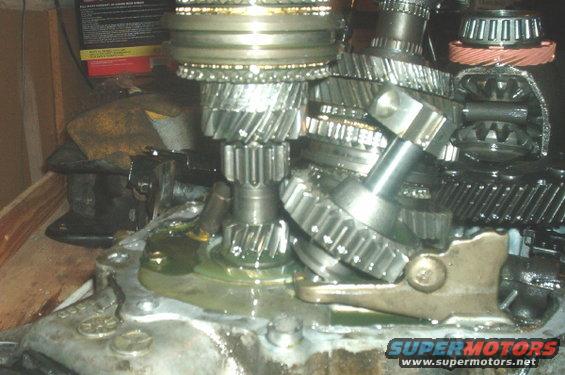 Transmission gears with lubricant, showing a complex arrangement of metal cogs and shafts