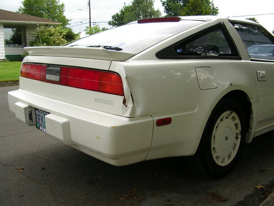 White 1989 Nissan 300ZX rear quarter panel with damage and a spoiler