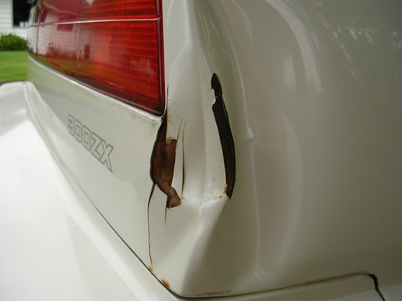 White 1989 Nissan 300ZX rear quarter panel with visible rust and damage near the taillight