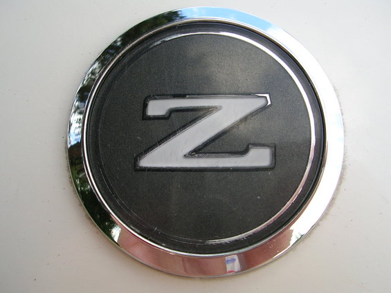 Close-up of a Nissan Z emblem on a white surface