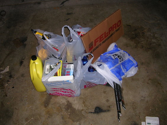 Shopping bags and a box of Fel-Pro gaskets on a concrete floor