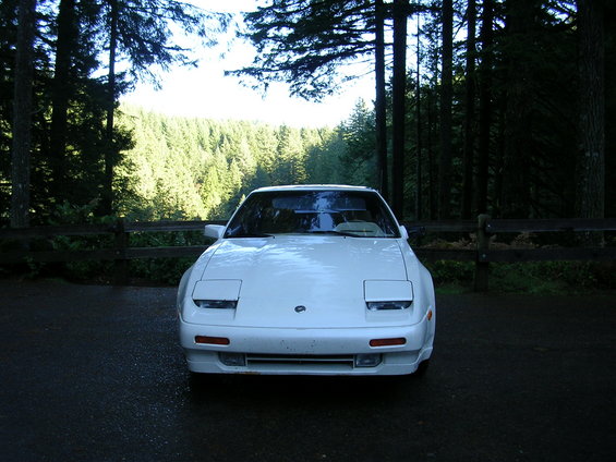 White sports car with pop-up headlights parked outdoors