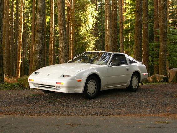 White Nissan 300ZX parked on gravel road in forest, 3/4 front view