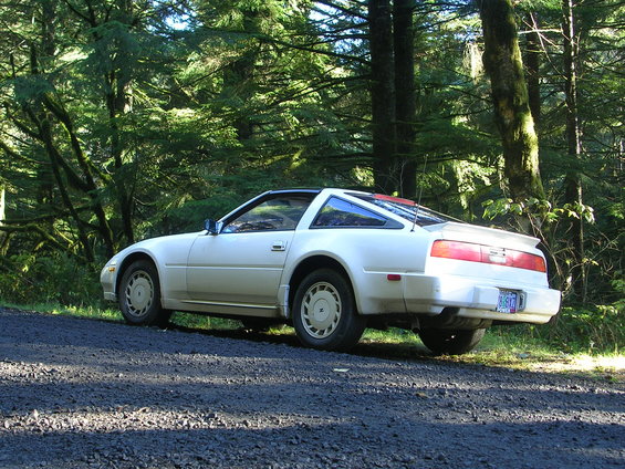 1989 Nissan 300ZX parked on gravel road, rear 3/4 view. Forest background