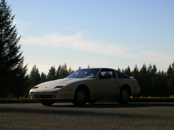 White 1989 Nissan 300ZX parked on asphalt with trees and sky in background