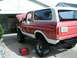 1979 Ford Bronco - This lifted Ford Bronco has its hood up, parked in front of a garage.