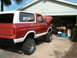1979 Ford Bronco - This lifted Ford Bronco is parked in a driveway with its hood open, revealing the engine bay.