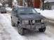 1996 Jeep Grand Cherokee - A dark-colored Jeep Grand Cherokee is parked on a snow-covered street with a brush guard and winch on the front.