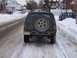 1996 Jeep Grand Cherokee - A Jeep Grand Cherokee sits on a snow-covered road, its spare tire prominently displayed on the rear.