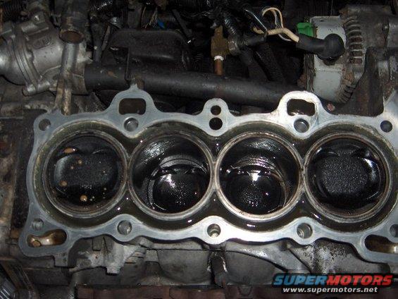 Engine block with pistons visible, part of a vehicle engine