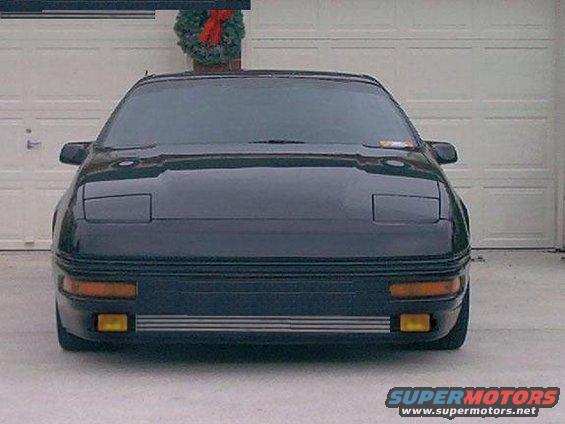 dark coupe parked in front of garage, wreath on garage door