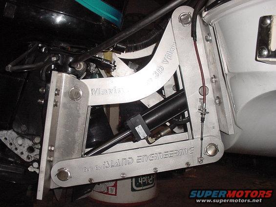 Boat motor mount with "Marine" and "ISLAND ENGINEERING" text, hydraulic cylinder, and black outboard motor