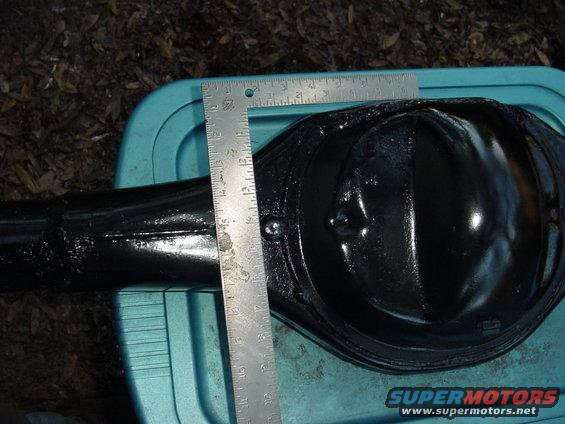 Black differential housing with a metal ruler measuring its width