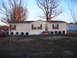 1988 Ford Bronco - A mobile home is seen with a red car and a white SUV in the yard.