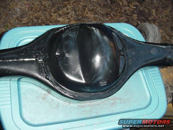 Black painted differential housing resting on a teal plastic container