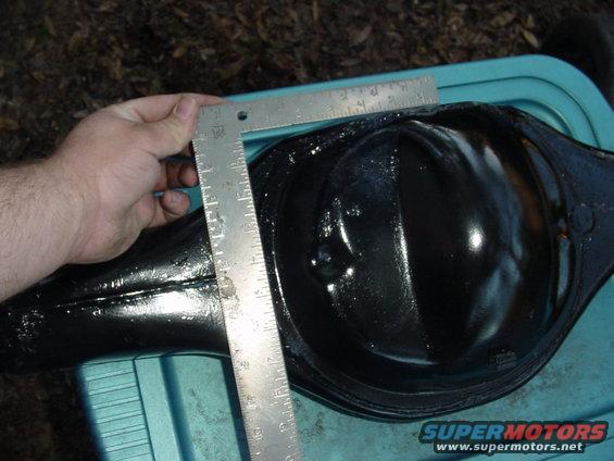 hand holding ruler against black rear axle differential housing