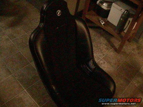 Black bucket seat with a circular logo on the headrest