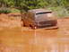 1978 Ford Bronco - This Chevrolet SUV is deeply stuck in a muddy puddle, with a 'For Sale' sign visible on the rear window.