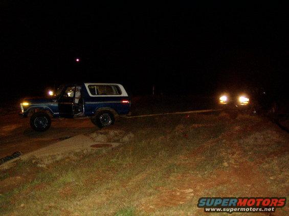1978 Ford Bronco side view at night, open door, another vehicle approaching
