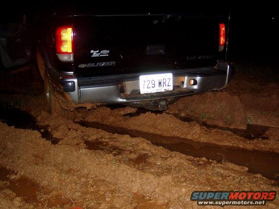 Rear of black pickup truck stuck in mud, license plate 729 WRZ