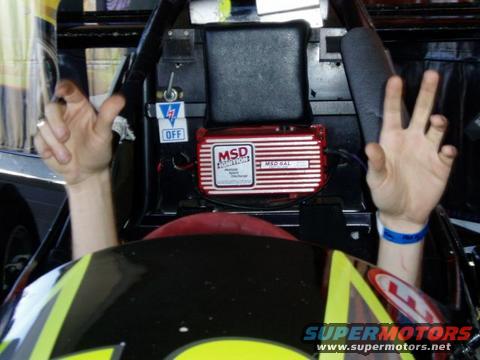 Race car interior with MSD ignition box and two hands raised