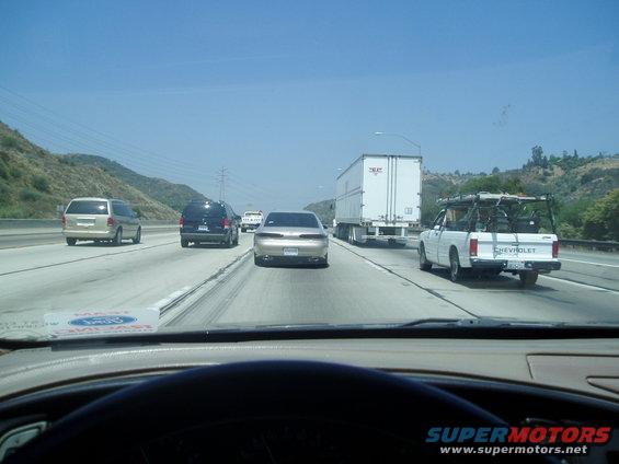 1998 Mercury Sable driving on highway behind a white Chevrolet pickup truck