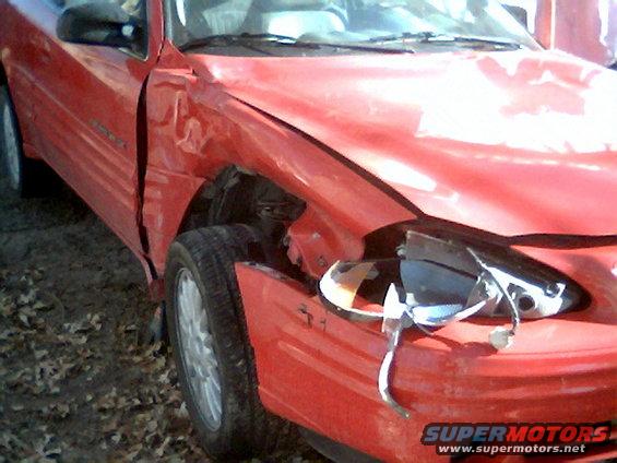 Damaged red car front fender and broken headlight
