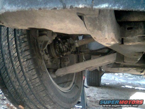 Undercarriage of a vehicle with a tire and suspension components visible