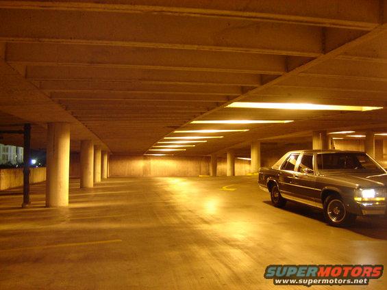 Silver sedan parked in a dimly lit concrete parking garage