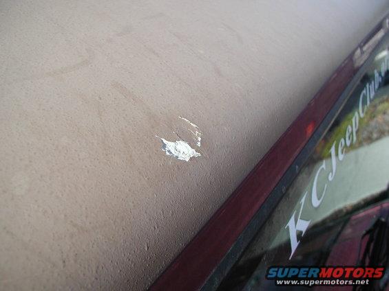 Paint chip on tan vehicle roof with 'KC Jeep Club' sticker visible