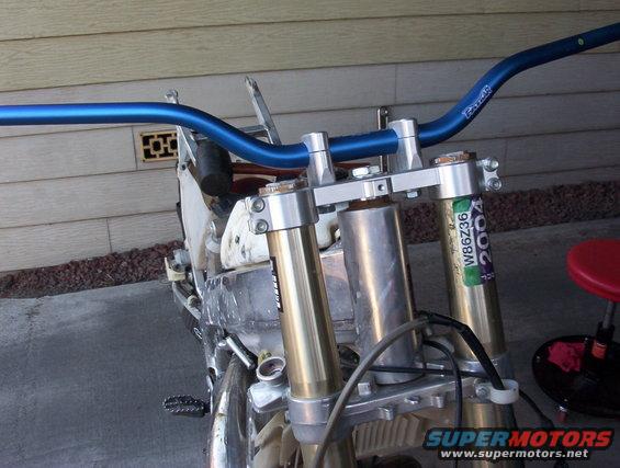 Blue handlebars and gold front suspension with a "2004" sticker