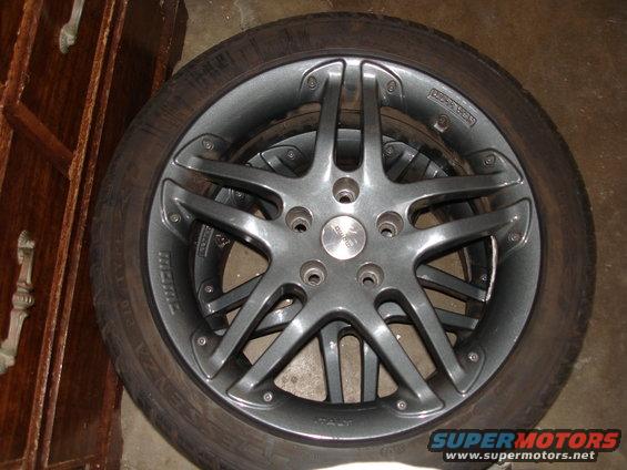 Gray five-spoke alloy wheel with tire, 'MOMO' and 'ITALY' visible