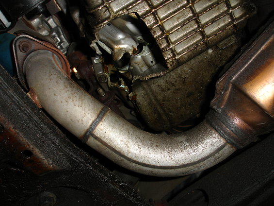Exhaust pipe and damaged oil pan under a vehicle