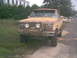 1986 Ford Bronco - This weathered Ford Bronco, likely from the early 1980s, sits parked on a dirt road.