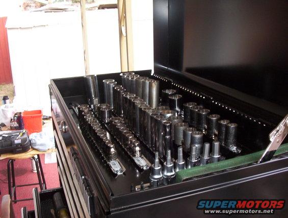 Black toolbox filled with various sockets and wrenches. A Supermotors.net watermark is visible