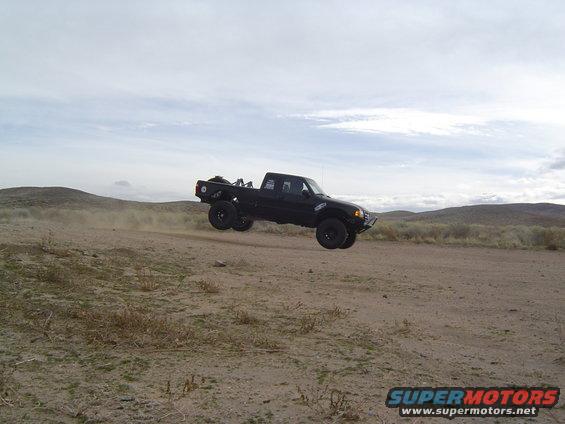 Black 1985 Ford Ranger mid-air jump, 3q-front view