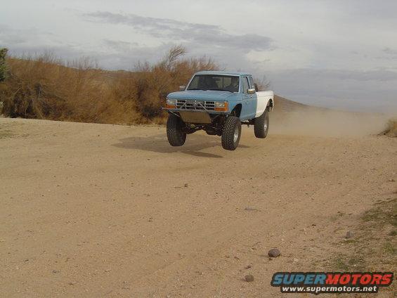 Blue and white 1985 Ford Ranger mid-air jump
