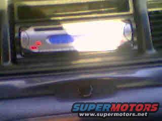 Aftermarket car stereo with blue display and red buttons installed in a dashboard