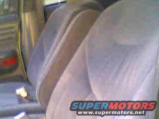 Interior view of light-colored fabric car seats with seatbelts