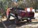 2001 Dodge 1500 - A maroon 2001 Dodge 1500 pickup truck is shown with large off-road tires, positioned on a dirt incline.
