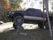2001 Dodge 1500 - A modified pickup truck is positioned on a tree stump, its off-road capabilities.
