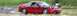 1997 Mitsubishi Eclipse - A red sports car is captured on a wet road surrounded by tall grass, with a watermark overlaying the image.