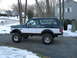 1994 Ford Bronco - A lifted 1992 Ford Bronco sits on a snowy driveway, its two-tone paint job visible.