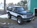 1994 Ford Bronco - This 1994 Ford Bronco features a two-tone dark green and white paint scheme and a prominent grille.