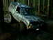 1987 Ford Bronco II - A 1987 Ford Bronco II navigates a muddy trail through a dense forest.