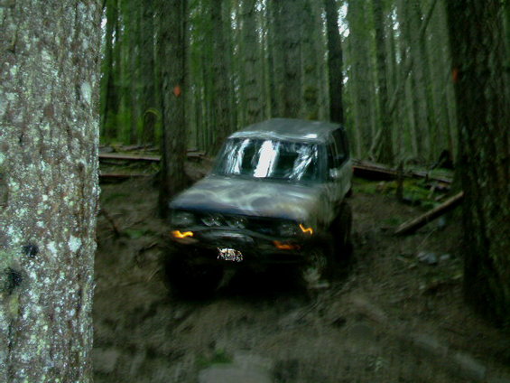 1987 Ford Bronco II driving off-road through a forest