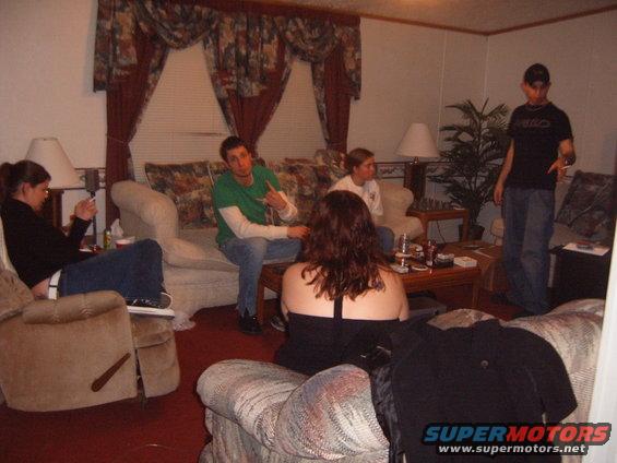 People gathered in a living room with couches and a coffee table