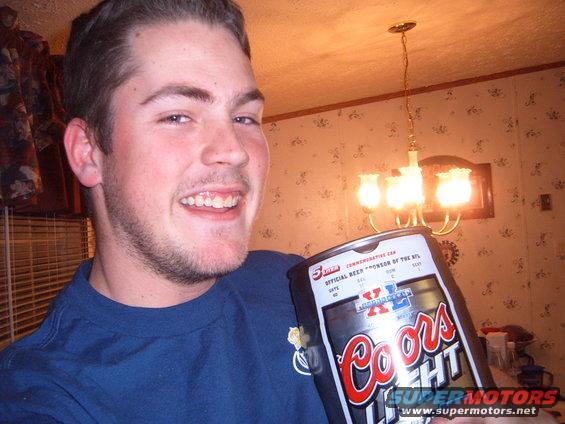 Man smiles holding a 5-liter Coors Light commemorative can, official beer sponsor of the NFL